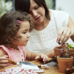 daughter helping her mother potting seedlings